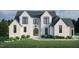 Charming exterior elevation of a two-story home with black windows and a well-manicured lawn at 297 Colonial Ridge Dr, Pittsboro, NC 27312