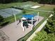 Aerial view of a community playground with slides, climbing structures, and a blue shade canopy, surrounded by lush greenery at 297 Colonial Ridge Dr, Pittsboro, NC 27312