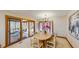 Dining room with sliding door access to the sunroom, with light wood table and chairs at 3306 Whitfield Rd, Chapel Hill, NC 27514