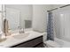 Bright bathroom featuring a vanity, a toilet, and a shower tub with blue patterned curtain at 3418 Longleaf Estates Dr, Raleigh, NC 27616