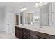 Bright bathroom featuring a large mirror, double vanity with dark cabinets, and tile flooring at 3418 Longleaf Estates Dr, Raleigh, NC 27616