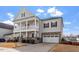 Charming two-story home with a two-car garage, a double stacked front porch, and landscaped front yard at 3418 Longleaf Estates Dr, Raleigh, NC 27616