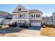 Elegant two-story home with a welcoming front porch and a well-kept lawn, showcasing suburban charm at 3418 Longleaf Estates Dr, Raleigh, NC 27616