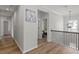 Upstairs hallway featuring wood floors and a pendant light at 3418 Longleaf Estates Dr, Raleigh, NC 27616