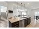 Bright kitchen featuring an island with granite countertops, stainless steel appliances, and wooden floors at 3418 Longleaf Estates Dr, Raleigh, NC 27616