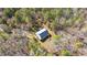 Aerial shot reveals a compact home nestled within a dense, verdant forest at 348 Raymond Tharrington Rd, Louisburg, NC 27549