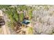 Secluded home nestled within dense trees, featuring a metallic roof, viewed from above at 348 Raymond Tharrington Rd, Louisburg, NC 27549