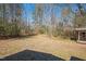 Expansive backyard view with mature trees and a rustic shed at 348 Raymond Tharrington Rd, Louisburg, NC 27549