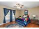 Cozy bedroom features hardwood flooring, ceiling fan, and bright natural light at 348 Raymond Tharrington Rd, Louisburg, NC 27549