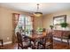 Cozy dining area with a traditional table, hardwood floors, and a view of outdoor greenery at 348 Raymond Tharrington Rd, Louisburg, NC 27549