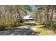 Charming home with a welcoming porch, surrounded by lush greenery and a gravel driveway at 348 Raymond Tharrington Rd, Louisburg, NC 27549