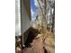A mulch bed leads to a backyard with a small, wood fence, a line of trees, and another house at 355 Riverstone Dr, Clayton, NC 27527