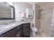 Stylish bathroom featuring granite counters, dark wood cabinetry, and a tiled walk-in shower at 355 Riverstone Dr, Clayton, NC 27527