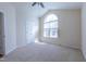 Bright bedroom featuring a large window with an arched top, plush carpeting, and neutral decor at 355 Riverstone Dr, Clayton, NC 27527