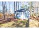 Backyard shed with ramp in wooded yard providing outdoor storage for tools and equipment at 355 Riverstone Dr, Clayton, NC 27527