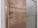 Elegant bathroom featuring a tiled shower with shelving and a glass door at 355 Riverstone Dr, Clayton, NC 27527