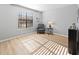 Cozy bedroom with a window, chair, lamp, and wood laminate flooring at 3803 Chimney Ridge Pl # 102, Durham, NC 27713