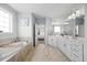 Bright bathroom featuring double vanity, large soaking tub and neutral tile at 3805 Barberry Lake Ct, Fuquay Varina, NC 27526
