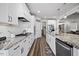 Modern kitchen boasts granite countertops, stainless steel appliances, white cabinetry, and a view into living room at 3805 Barberry Lake Ct, Fuquay Varina, NC 27526
