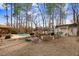 Backyard with a pool, mature trees, sheds, and a covered porch at 3836 Gloucester Rd, Rocky Mount, NC 27803