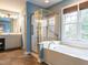 Bright bathroom with a soaking tub, glass shower, neutral vanity and natural lighting from a large window at 426 Fincastle Dr, Cary, NC 27513