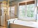 Bright bathroom with a glass shower, soaking tub, and natural light from the large window at 426 Fincastle Dr, Cary, NC 27513