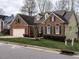 A brick home featuring a two-car garage, dormer windows, and manicured front lawn at 426 Fincastle Dr, Cary, NC 27513