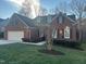 Charming brick home featuring a two-car garage, dormer windows, and green front lawn at 426 Fincastle Dr, Cary, NC 27513