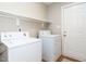 Well-lit laundry room features a washer and dryer with convenient overhead shelving and a door to the outside at 426 Fincastle Dr, Cary, NC 27513