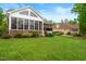 Expansive backyard featuring a lush lawn, mature landscaping, and a sunroom at 498 Mountain Laurel, Chapel Hill, NC 27517
