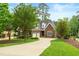 Charming brick home features a well-manicured lawn and a long driveway leading to a two-car garage at 498 Mountain Laurel, Chapel Hill, NC 27517