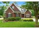 Charming brick home with lush landscaping, dark shutters, and a well-maintained lawn at 498 Mountain Laurel, Chapel Hill, NC 27517