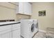 A pristine laundry room including white cabinets, sink and a high efficiency washer and dryer at 498 Mountain Laurel, Chapel Hill, NC 27517