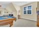 Large bonus room with pool table, bar with shelving, and comfortable seating at 498 Mountain Laurel, Chapel Hill, NC 27517
