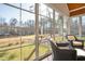 Sunroom with large windows offering views of a manicured backyard and lush greenery at 498 Mountain Laurel, Chapel Hill, NC 27517