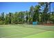 A well-maintained community tennis court surrounded by lush trees, perfect for recreational play at 498 Mountain Laurel, Chapel Hill, NC 27517