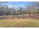 Expansive backyard with mature trees and a seating area at 520 Log Barn Rd, Pittsboro, NC 27312