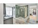 Bright bathroom featuring a walk-in glass shower with decorative tile and updated gray cabinets at 520 Log Barn Rd, Pittsboro, NC 27312