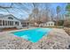 Beautiful in-ground pool with a stone patio, hot tub, and an outdoor dining area for elegant entertaining at 520 Log Barn Rd, Pittsboro, NC 27312