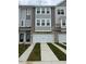 Modern townhome featuring a two-car garage, stone accents, and gray siding at 5322 River Reach Dr, Raleigh, NC 27616