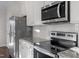 Galley kitchen featuring stainless appliances, white cabinets and subway tile backsplash at 5322 River Reach Dr, Raleigh, NC 27616