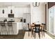 Modern kitchen with stainless steel appliances, white cabinets, and a dining area at 5322 River Reach Dr, Raleigh, NC 27616