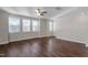 Bright living room with hardwood floors, ceiling fan and many windows providing natural light at 5322 River Reach Dr, Raleigh, NC 27616
