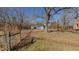 A large backyard featuring mature trees, a storage building, and fence lines for security at 5436 New Oak Trl, Burlington, NC 27217