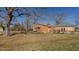 View of the backyard featuring mature trees, a brick exterior, and access to a patio area at 5436 New Oak Trl, Burlington, NC 27217