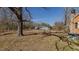 Expansive backyard with a metal storage building and mature trees offering shade and privacy at 5436 New Oak Trl, Burlington, NC 27217