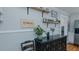 A dining room featuring a black cabinet with shelves and plants, complemented by light gray walls and open shelving at 5436 New Oak Trl, Burlington, NC 27217