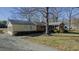 Inviting exterior featuring a brick and yellow siding, large shade tree and a well-maintained gravel driveway at 5436 New Oak Trl, Burlington, NC 27217