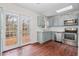 Sunlit kitchen with stainless appliances, blue cabinets, and French doors to the deck at 7 Harrigan Ct, Durham, NC 27705