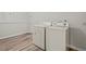 Neat laundry room with modern white washer and dryer on wood plank flooring at 7 Harrigan Ct, Durham, NC 27705